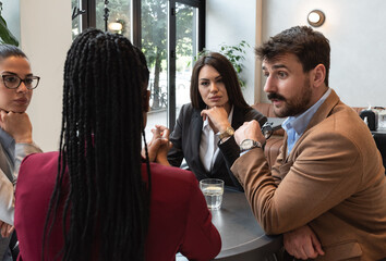 Group of young freelancers real estate agents have business meeting in cafeteria discussing about prices and situation on the rental and selling market of houses and apartments. Selective focus