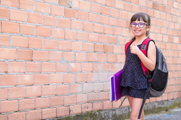 happy student girl with backpack and books making ok sign with fingers