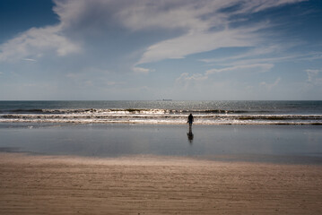 Fototapeta na wymiar Silhouette of Woman walking on beach at sunriseff