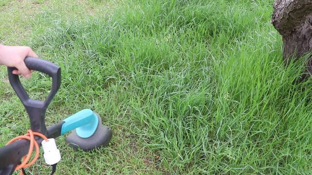 Closeup of a person mowing green grass