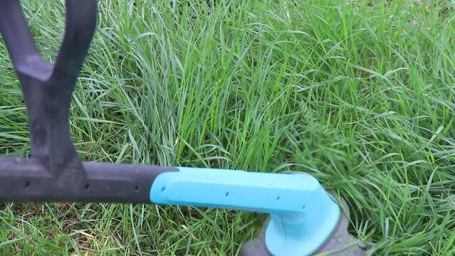 Closeup of a person mowing green grass