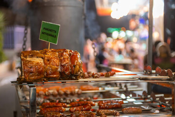stall where typical Italian meat recipe called porchetta artisan is roasted during a patronal feast...