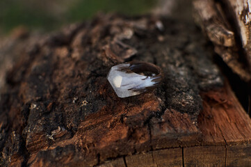 Photo of a ring made of epoxy resin lying on a texture cut of a tree. Eco-friendly material to create beautiful things. Bright unusual gift for a girl. Epoxy resin is often used for decor.