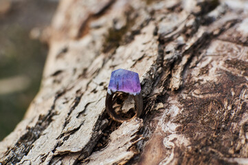 Photo of a ring made of epoxy resin lying on a texture cut of a tree. Eco-friendly material to create beautiful things. Bright unusual gift for a girl. Epoxy resin is often used for decor.