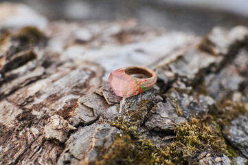 Photo of a ring made of epoxy resin lying on a texture cut of a tree. Eco-friendly material to create beautiful things. Bright unusual gift for a girl. Epoxy resin is often used for decor.
