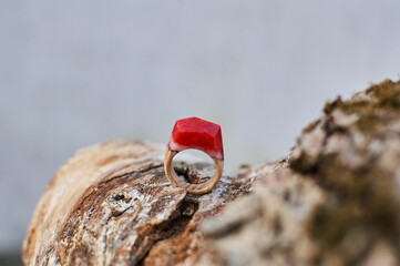 Photo of a ring made of epoxy resin lying on a texture cut of a tree. Eco-friendly material to create beautiful things. Bright unusual gift for a girl. Epoxy resin is often used for decor.