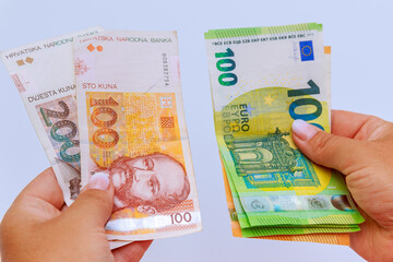 Euro and kuna in the hands of a banker on a white background. Bills of various denominations.