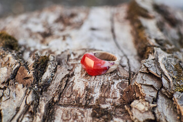 Photo of a ring made of epoxy resin lying on a texture cut of a tree. Eco-friendly material to create beautiful things. Bright unusual gift for a girl. Epoxy resin is often used for decor.