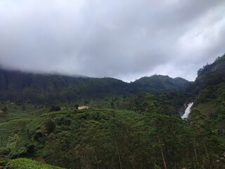 Fototapeta premium Water falls inside cloudy mountain tea valley