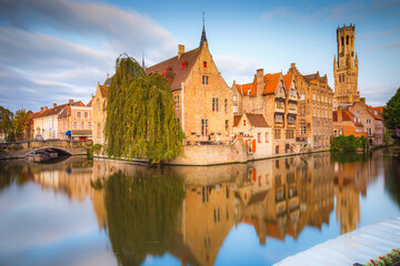 Fototapeta na wymiar Rozenhoedkaai canal reflection at sunrise and blurred clouds, Bruges