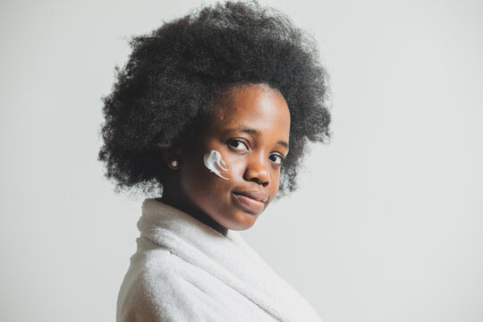 Portrait of a woman with a dab of cream on her face