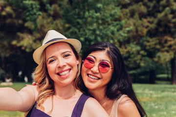 Smiling friends taking a selfie portrait. women of different ethnicities smiling at the camera.