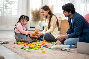 A handsome Arab man and his Asian wife playing with their daughter after a break from work at home.