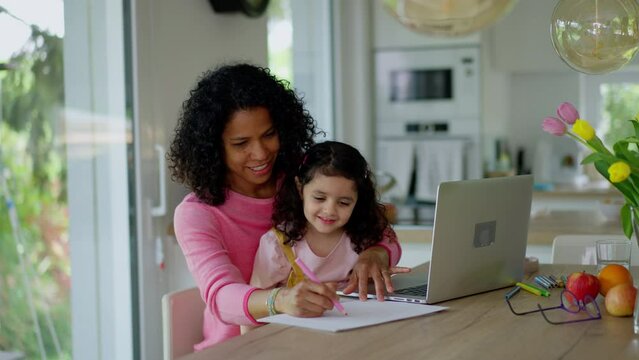 Mother working from home while child is sitting with her. Home office concept.