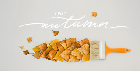 Brush draws with paints from leaves, creative concept of autumn leaf fall Banner with text hello autumn