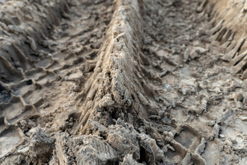 A deep car track on a Russian dirt road after rain. The imprint of car tires on the dirt. Dried mud on the roads in the village.