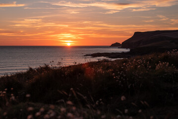 Fototapeta premium sunset over the sea beach cliffs hills rocks island meadow warmth