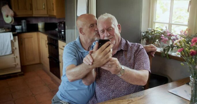MS Senior gay couple taking selfie at home / East Sussex, UK