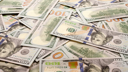 Pile of one hundred dollar bills of a new design as a background. Banknotes of 100 US dollars, new paper money in cash. Background with American one hundred dollar bills. Business concept.