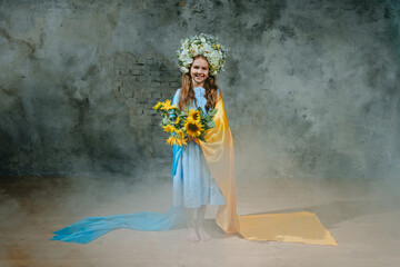 Little girl in ethnic dress wearing flower wreath with Ukrainian flag