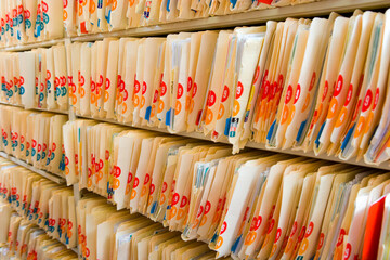 Rows and rows of paper medical records fill a hallway.