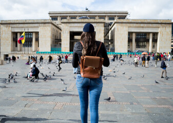 Mujer admirando, mujer de espaldas admirando palomas en la plaza
