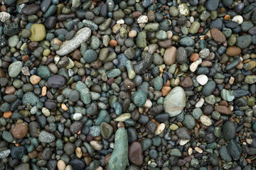 Pebble beach stones background, natural rounded gravel on the seashore nature background texture pattern