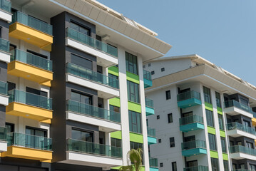 Modern freshly built apartment buildings on a sunny day with blue sky.