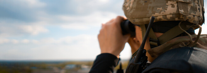 A Man with a binocular and  in the military uniform.