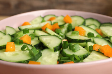 Tasty fresh salad with cucumber in bowl, closeup