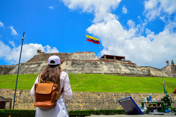 Admirando Colombia, Mujer viendo la bandera de Colombia en lo alto - obrazy, fototapety, plakaty