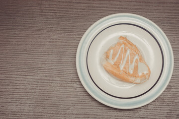 French toast, individual portion with peanut butter and condensed milk ready to spread on white ceramic plate with isolated wooden background.