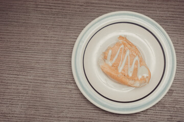 French toast, individual portion with peanut butter and condensed milk ready to spread on white ceramic plate with isolated wooden background. Top view.