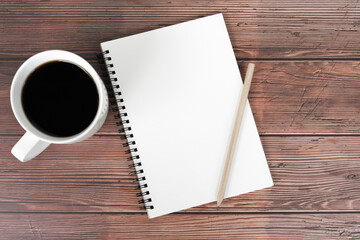 Blank note pad with cup of coffee and pencil flat lay