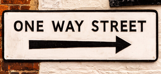 Modern One Way Street Sign on a Wall with Arrow indicating Left to Right