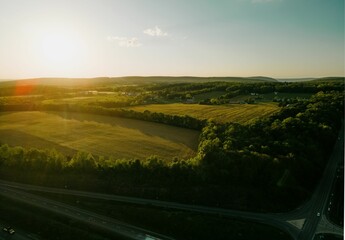 Beautiful drone landscape over lush farm fields and highways under sunset sky in Pennsylvania