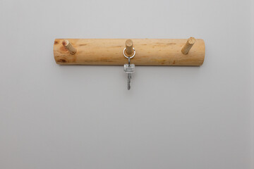 Hanging keys on the wall, one keys  on wooden hanger
