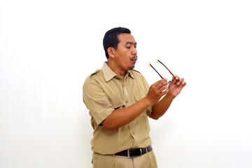 Indonesian government employees standing blowing and cleaning glasses. Isolated on white