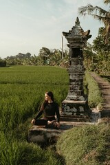 Young woman in lotus position practicing yoga in Bali rice field
