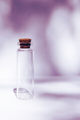 Modern apothecary concept. Empty glass miniature bottle with cork cap on contrast shadows background. Still life compositions