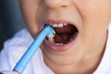 The child brushes his teeth close-up.