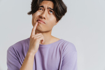 Young handsome thoughtful asian boy touching his chin