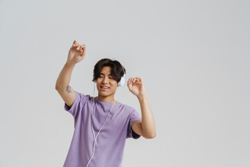 Young asian boy in headphones with closed eyes dancing