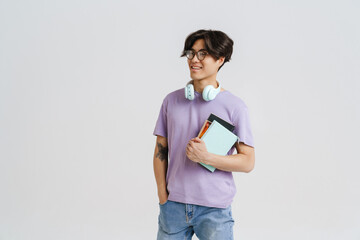 Young handsome smiling asian boy in glasses holding books