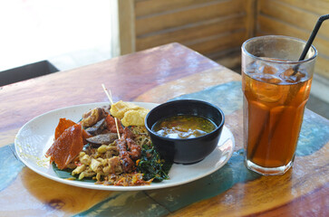 a photo of balinese rice dish of roast pork or usually called nasi campur babi guling with natural light.