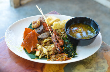 a photo of balinese rice dish of roast pork or usually called nasi campur babi guling with natural light.