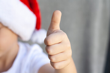 The child holds a toothbrush and shows a thumbs up. Close frame.