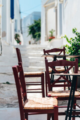 Empty cafe tables on streets of village of Pyrgos with Cycladic houses on Tinos island, Cyclades, Greece