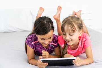people, children, technology, friends and friendship concept - girls looking to tablet pc computers at home