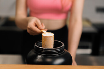 Fototapeta na wymiar Curvy women make a protein shake at the fitness health bar in the gym